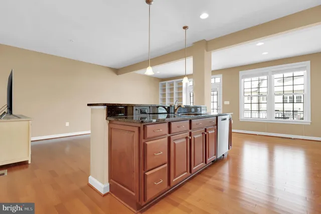 a kitchen with granite countertop a stove a sink and a microwave