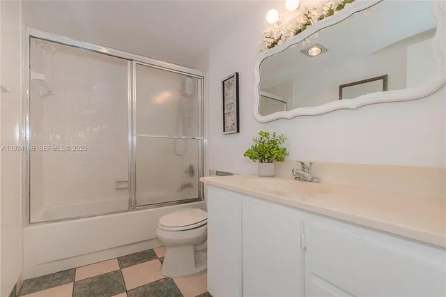 a bathroom with a granite countertop sink a toilet and shower