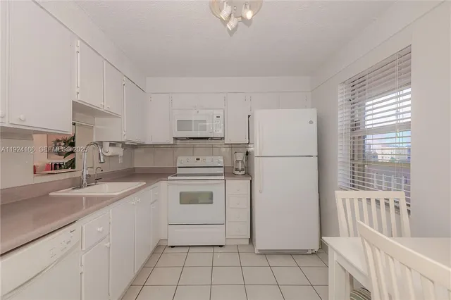 a kitchen with white cabinets and white appliances