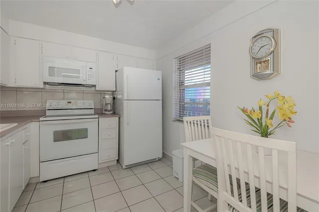 a kitchen with white cabinets and white appliances