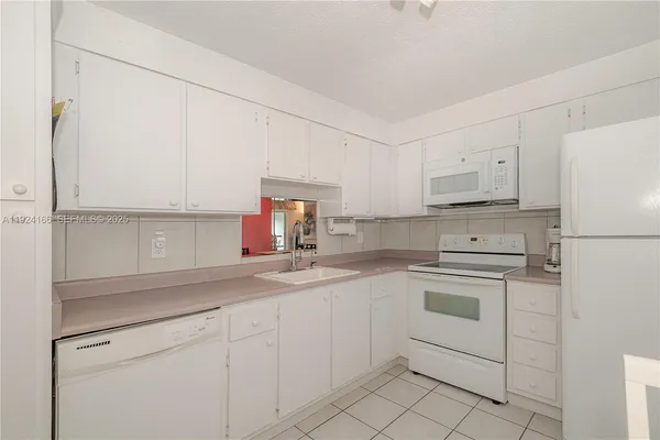 a kitchen with cabinets appliances a sink and a counter space
