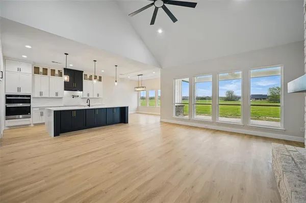 a large kitchen with stainless steel appliances a large counter top a stove and a wooden floors