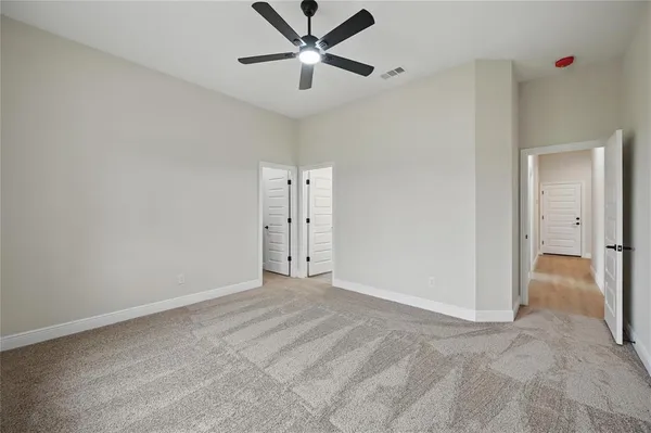 an empty room with windows and cabinet