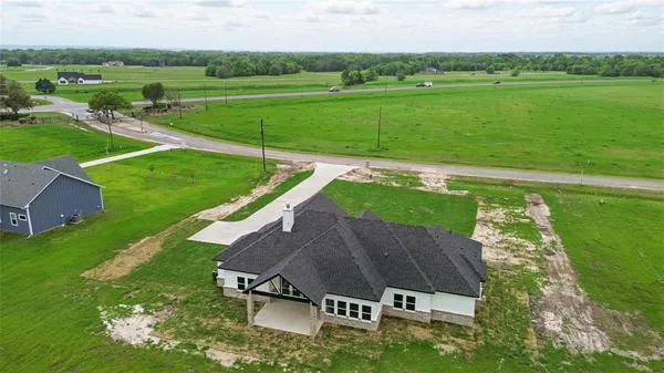 an aerial view of a house with a big yard
