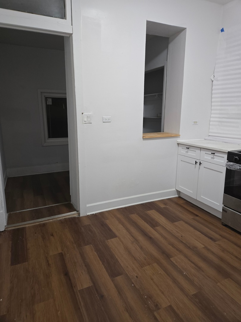 6229 South Bishop Street, Unit 1 Chicago, IL 60636 - Photo 2 of 17 an empty room with wooden floor and cabinet