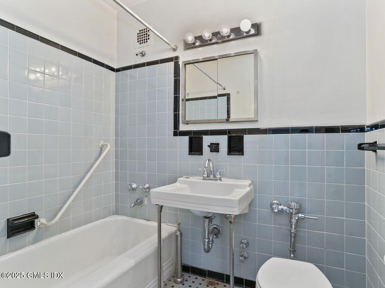 3 Putnam Hill, Unit 2B Greenwich, CT 06830 - Photo 19 of 23 a bathroom with a sink a toilet a mirror and bathtub