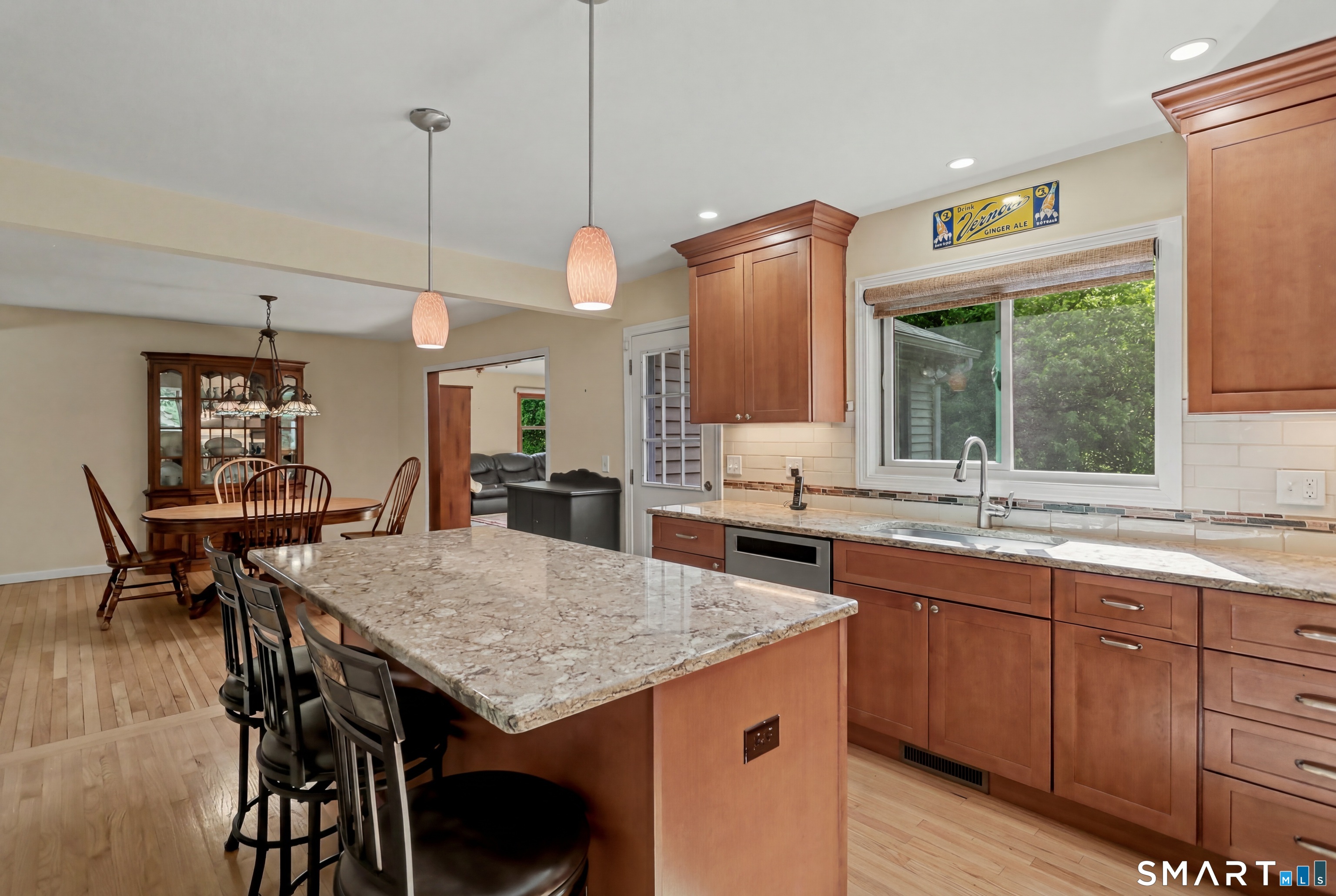 632 Wheelers Farm Road Orange, CT 06477 - Photo 10 of 39 a kitchen with granite countertop a table chairs sink and wooden floor