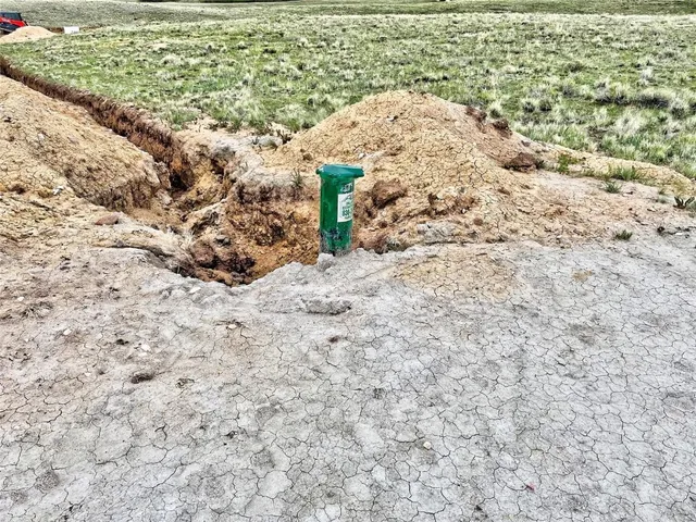 a view of a dry yard with wooden fence