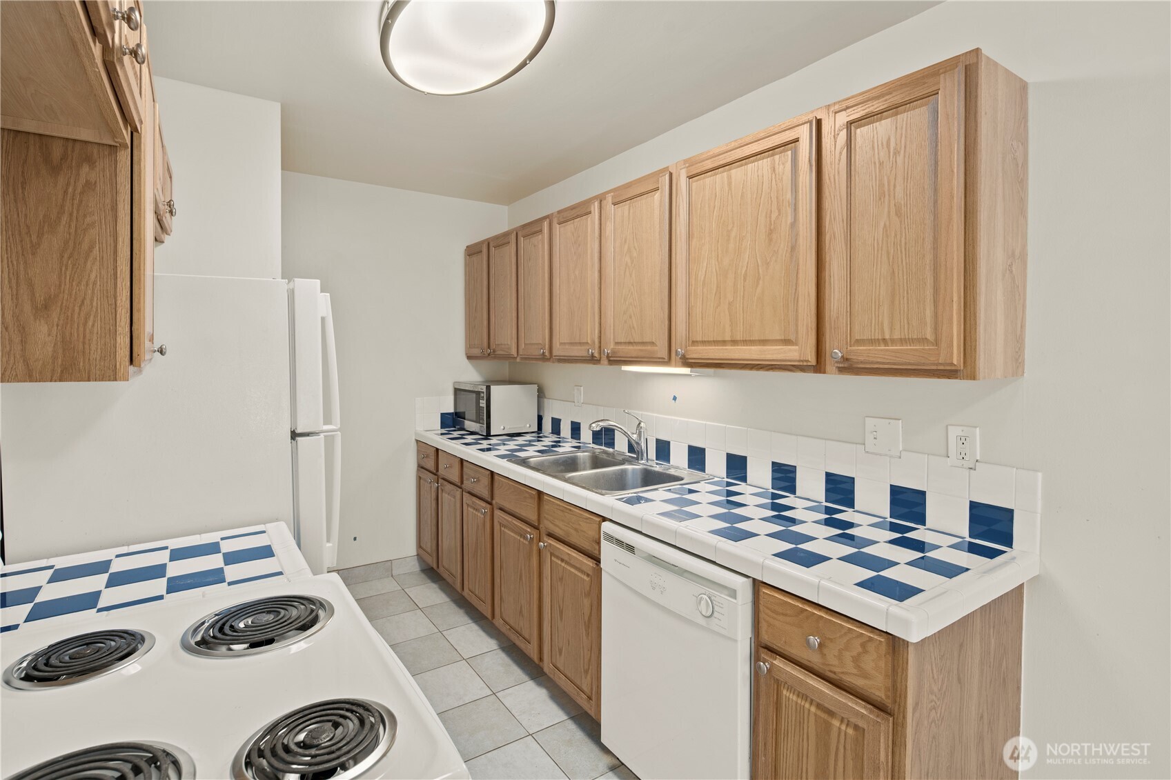 509 19th Avenue East Seattle, WA 98112 - Photo 14 of 40 a kitchen with a stove and a white cabinets