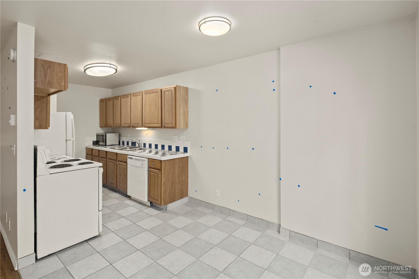 509 19th Avenue East Seattle, WA 98112 - Photo 10 of 40 a kitchen with a refrigerator and white cabinets