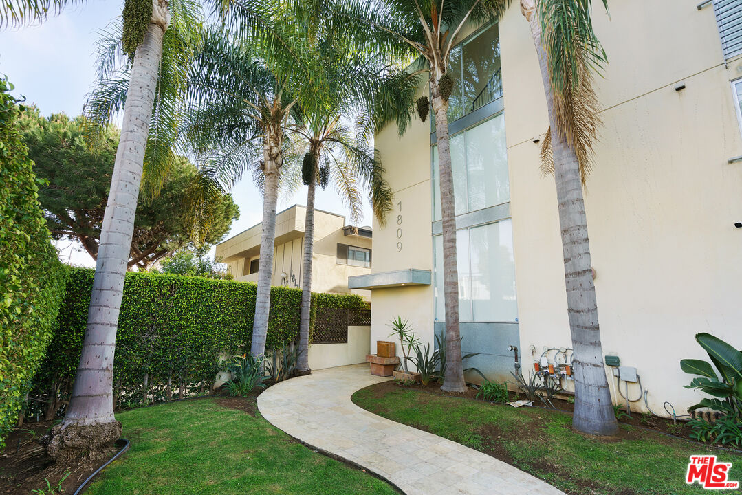 1809 Overland Avenue, Unit 5 Los Angeles, CA 90025 - Photo 1 of 15 a view of a white house with a yard and palm trees