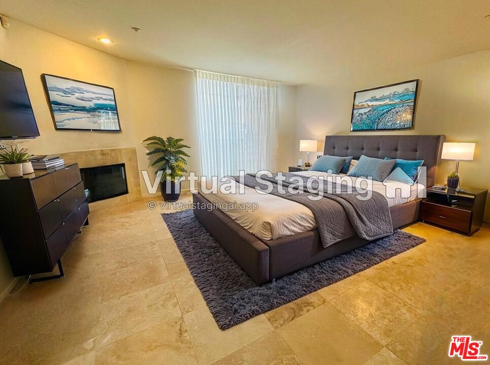 1809 Overland Avenue, Unit 5 Los Angeles, CA 90025 - Photo 11 of 15 a spacious bedroom with a bed a couch and paintings on the wall