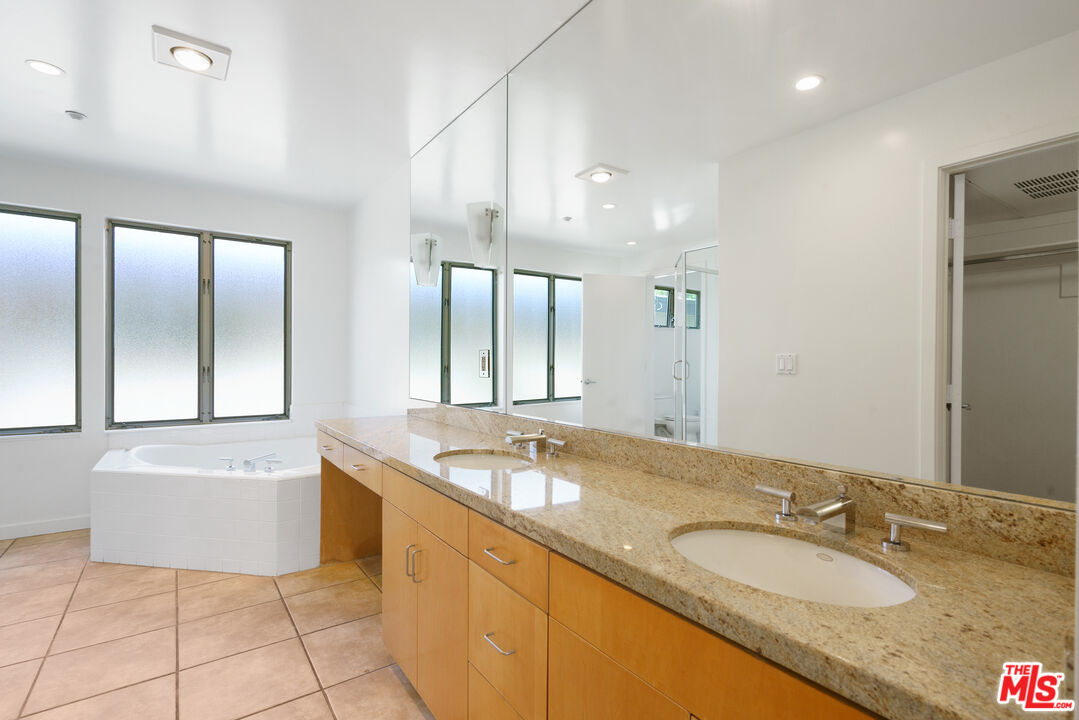 1809 Overland Avenue, Unit 5 Los Angeles, CA 90025 - Photo 12 of 15 a bathroom with a granite countertop bathtub sink and mirror