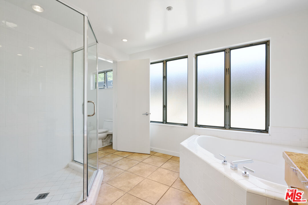 1809 Overland Avenue, Unit 5 Los Angeles, CA 90025 - Photo 13 of 15 a bathroom with a tub a mirror and a shower