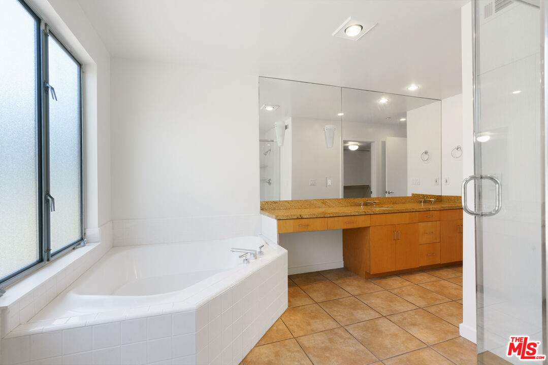1809 Overland Avenue, Unit 5 Los Angeles, CA 90025 - Photo 14 of 15 a bathroom with a bathtub a sink and a mirror