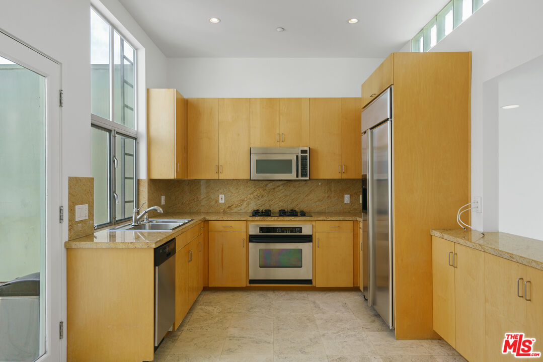 1809 Overland Avenue, Unit 5 Los Angeles, CA 90025 - Photo 8 of 15 a kitchen with stainless steel appliances granite countertop a stove a sink and a refrigerator