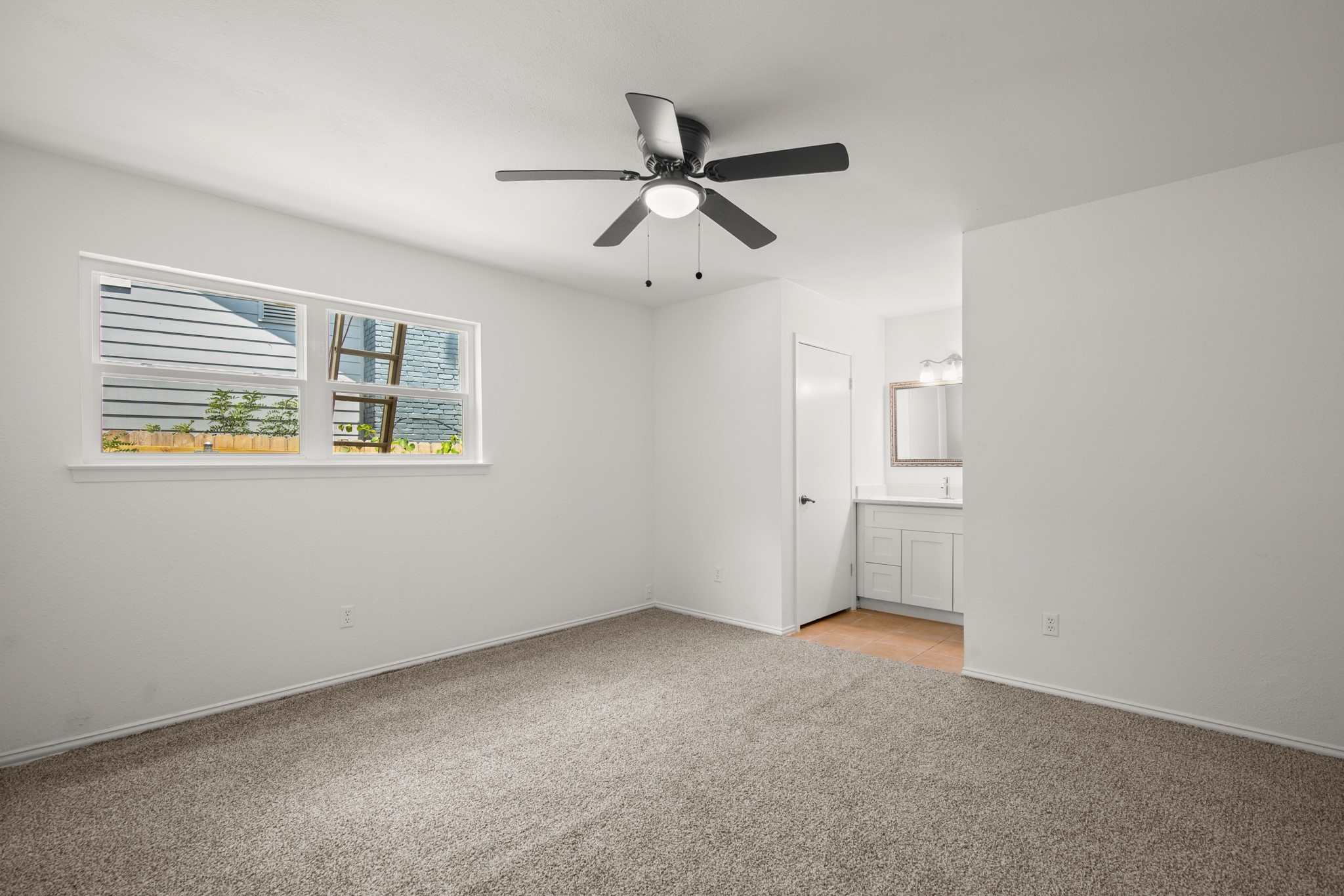 2109 Brandywine Lane Austin, TX 78727 - Photo 11 of 27 Primary bedroom with light carpet, ensuite bathroom, and a ceiling fan