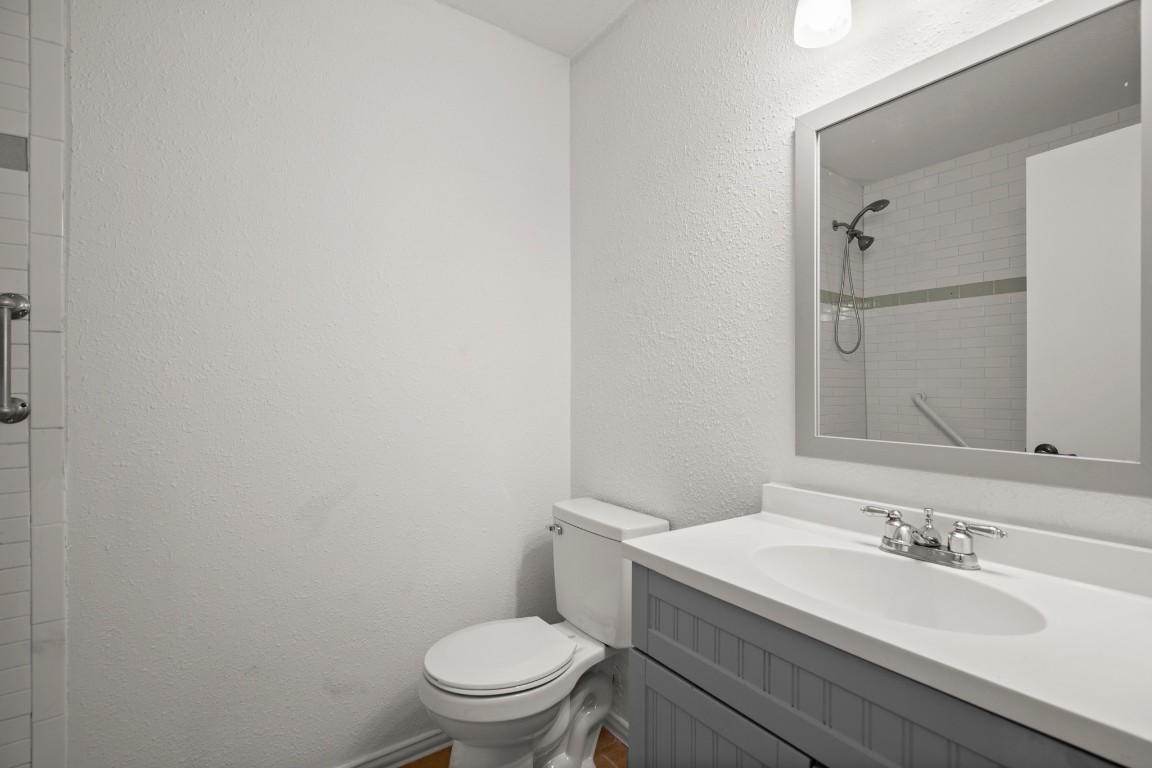 2109 Brandywine Lane Austin, TX 78727 - Photo 15 of 27 a bathroom with a granite countertop toilet a sink and mirror