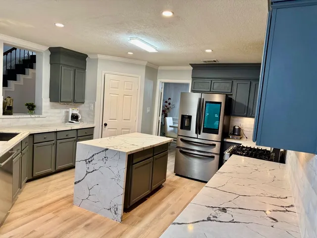 a kitchen with stainless steel appliances granite countertop a sink stove and refrigerator
