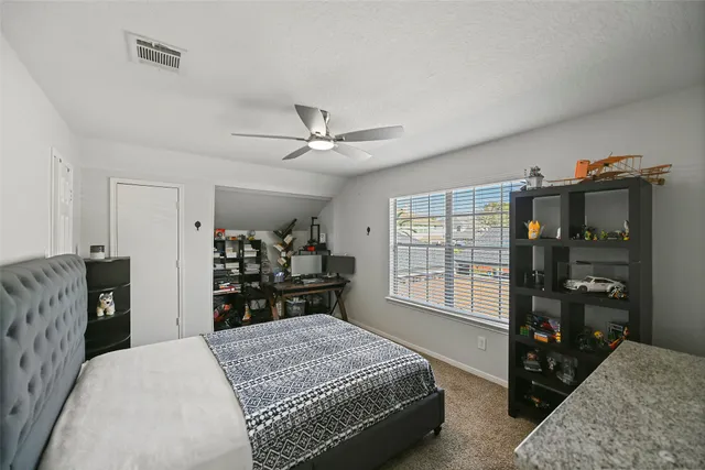 a bedroom with a bed and a flat tv screen on dresser