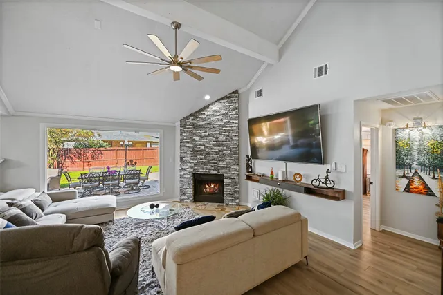 a living room with furniture a flat screen tv and a fireplace