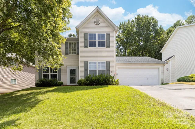 a front view of a house with garage and yard