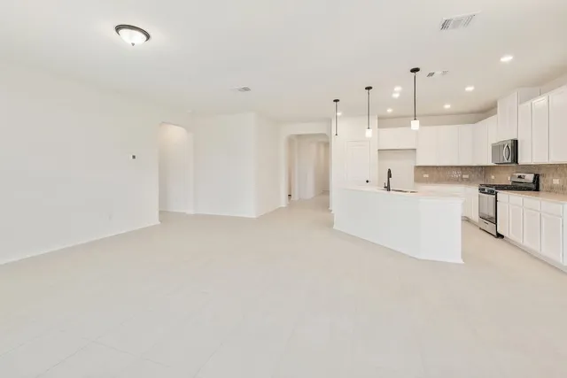 a large white kitchen with cabinets and a refrigerator