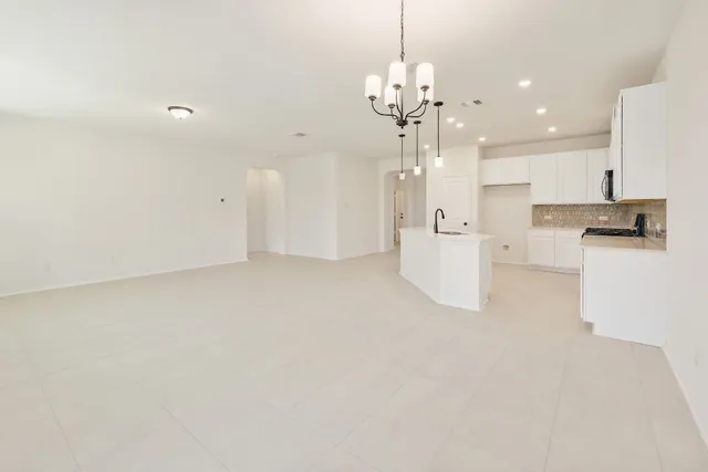 a view of a kitchen with a refrigerator a kitchen island and a sink