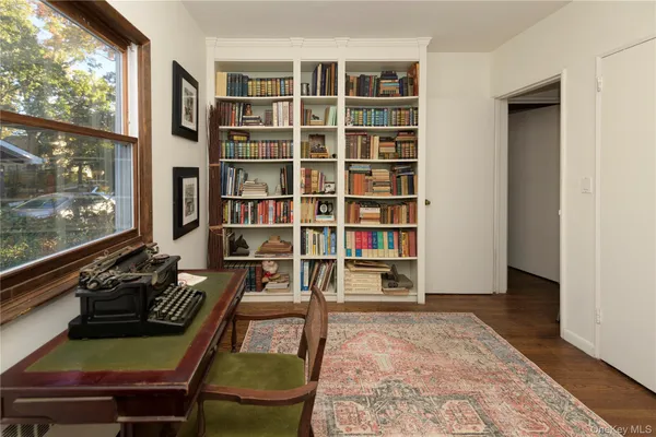 a living room with furniture and a book shelf