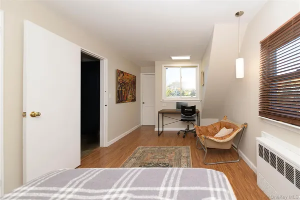 a living room with a baby crib furniture a window and a potted plant
