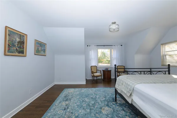 a spacious bedroom with two beds and painting on the wall