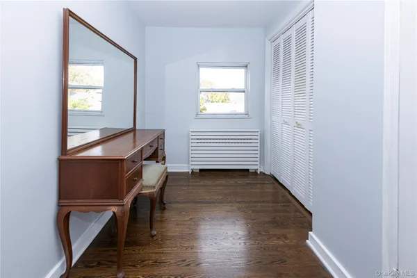 a view of a hallway with wooden floor and a window