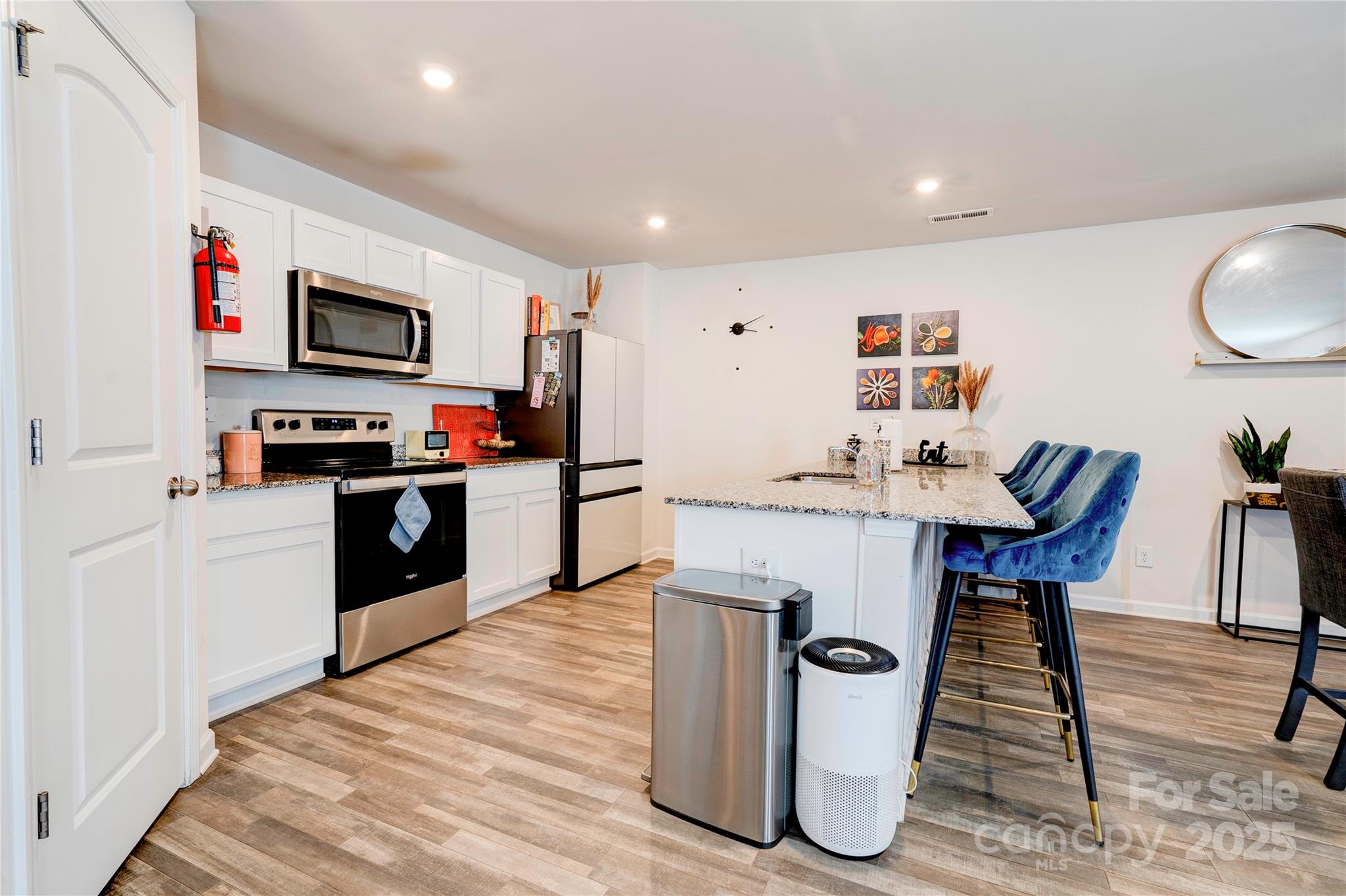 2344 Joes Lake Road Shelby, NC 28152 - Photo 26 of 47 a kitchen with stainless steel appliances granite countertop a refrigerator a stove top oven a sink dishwasher and white cabinets with wooden floor