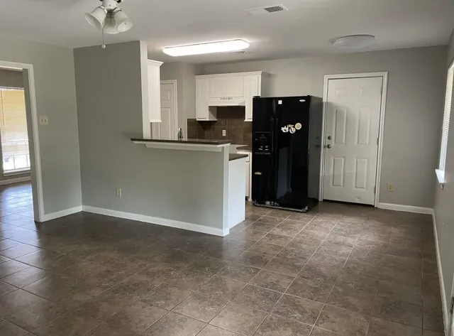 a view of kitchen with refrigerator and window