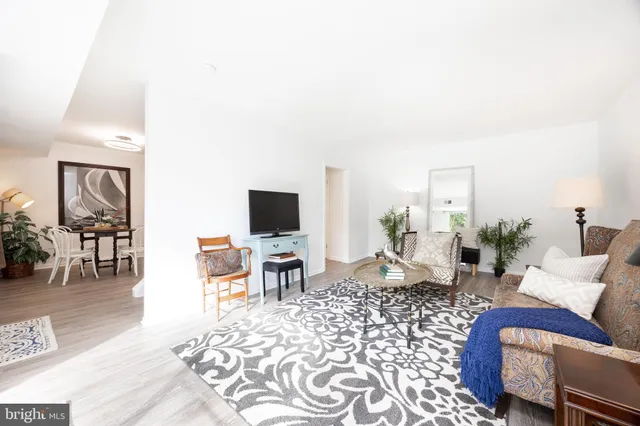 a living room with furniture a flat screen tv and a table