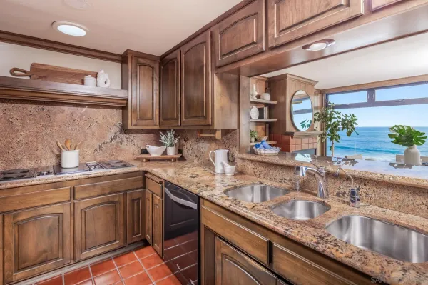 a kitchen with stainless steel appliances granite countertop a sink stove and cabinets