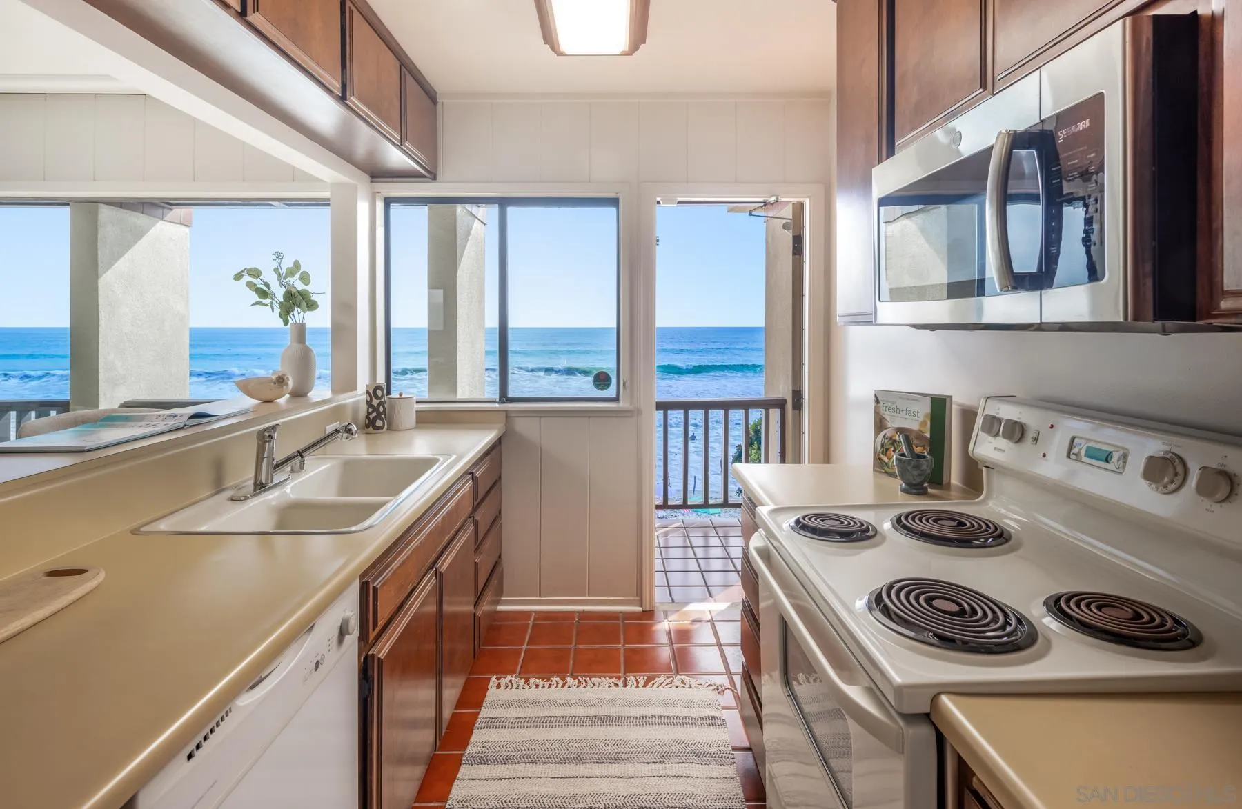 2977 Ocean Street Carlsbad, CA 92008 - Photo 21 of 44 a kitchen with a sink a stove and a window with wooden floor