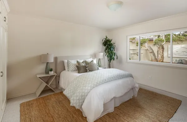 a bed sitting in a bedroom next to a window