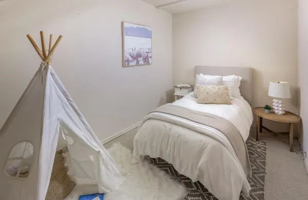 a bedroom with a bed and a painting on the wall