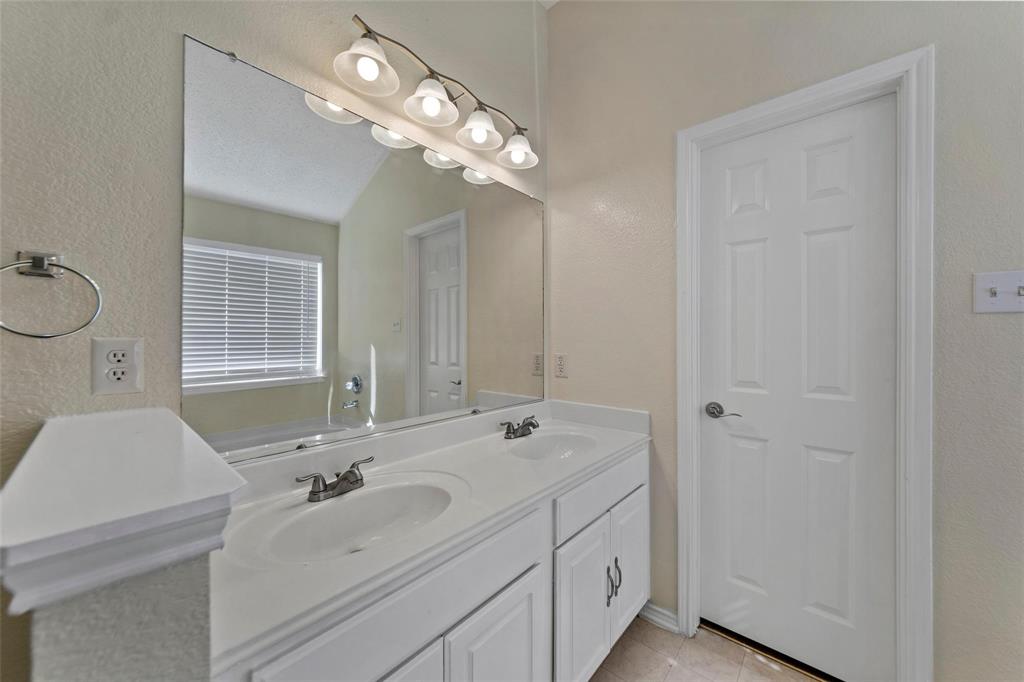 1002 Manassas Drive Forney, TX 75126 - Photo 19 of 26 a bathroom with a double vanity sink and a mirror