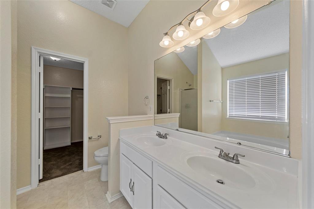 1002 Manassas Drive Forney, TX 75126 - Photo 20 of 26 a spacious bathroom with a double vanity sink a large mirror and a shower
