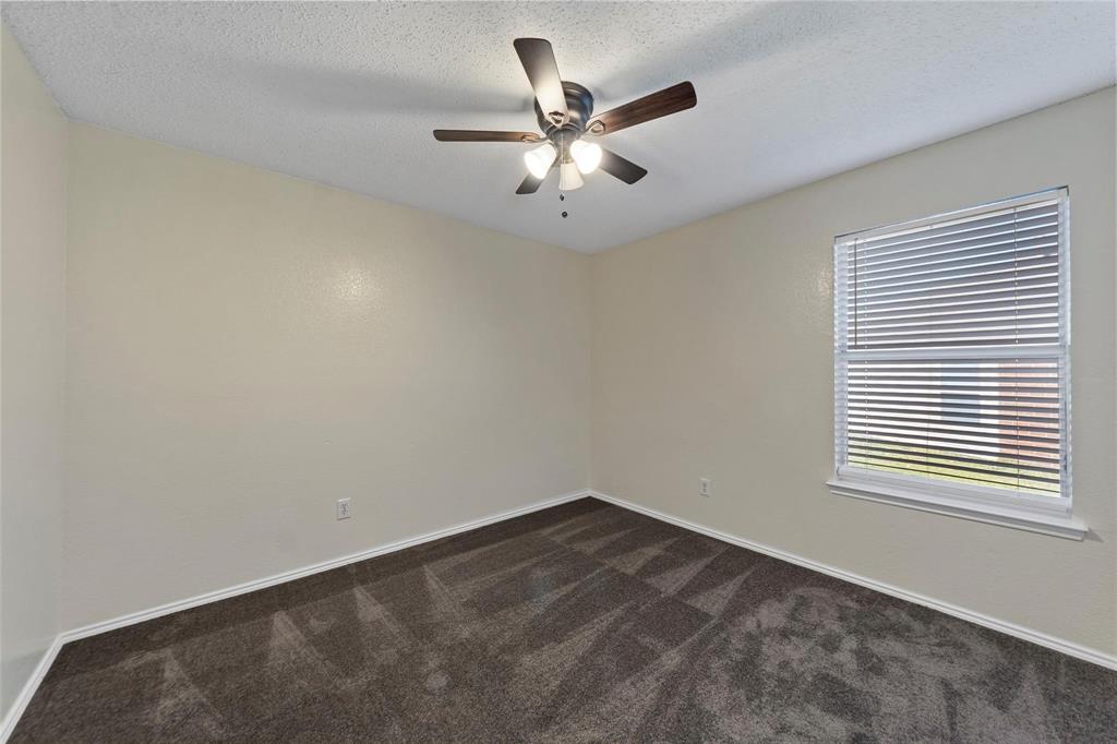 1002 Manassas Drive Forney, TX 75126 - Photo 7 of 26 an empty room with a window and a ceiling fan