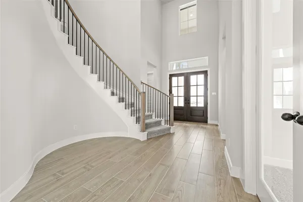 a view of staircase with wooden floor and fan