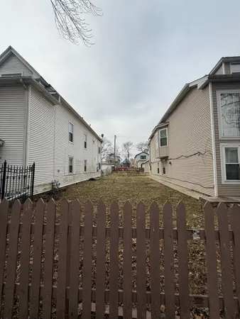 a view of a street with wooden fence
