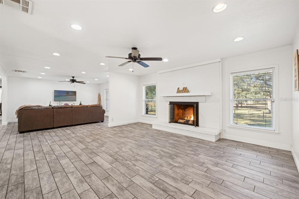12414 Fort King Road Dade City, FL 33525 - Photo 13 of 60 a view of an empty room with a fireplace and a window