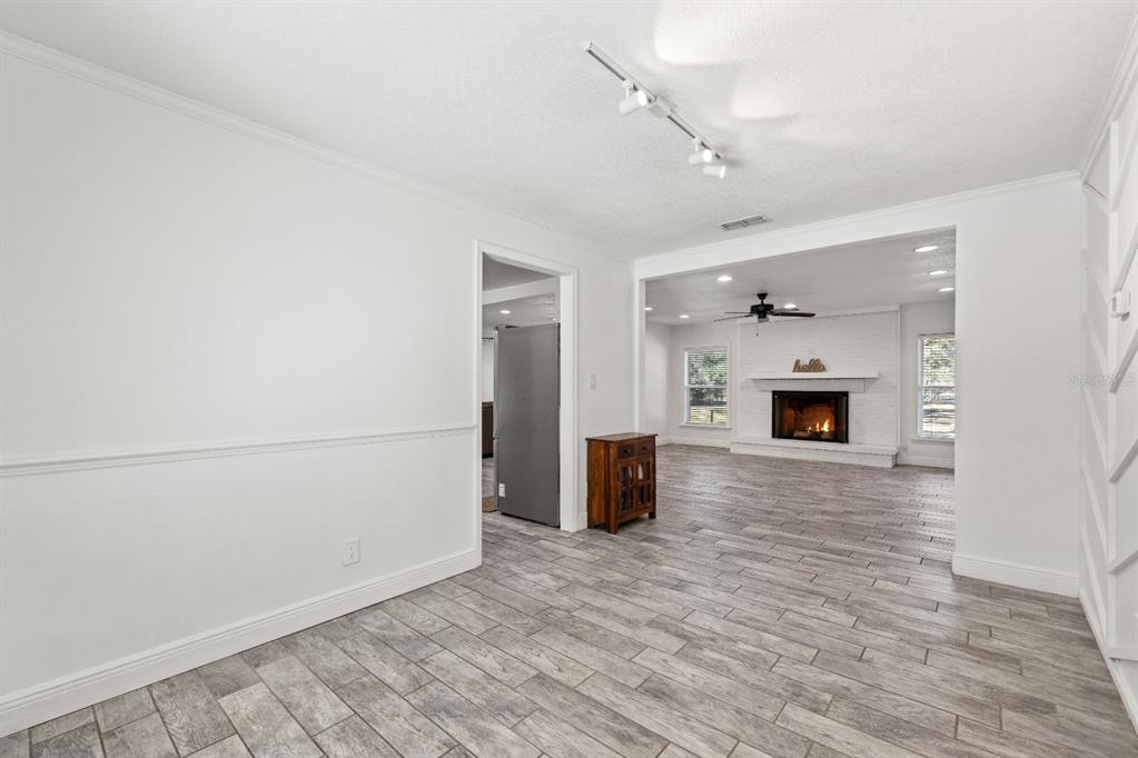 12414 Fort King Road Dade City, FL 33525 - Photo 27 of 60 a view of empty room with wooden floor and fireplace