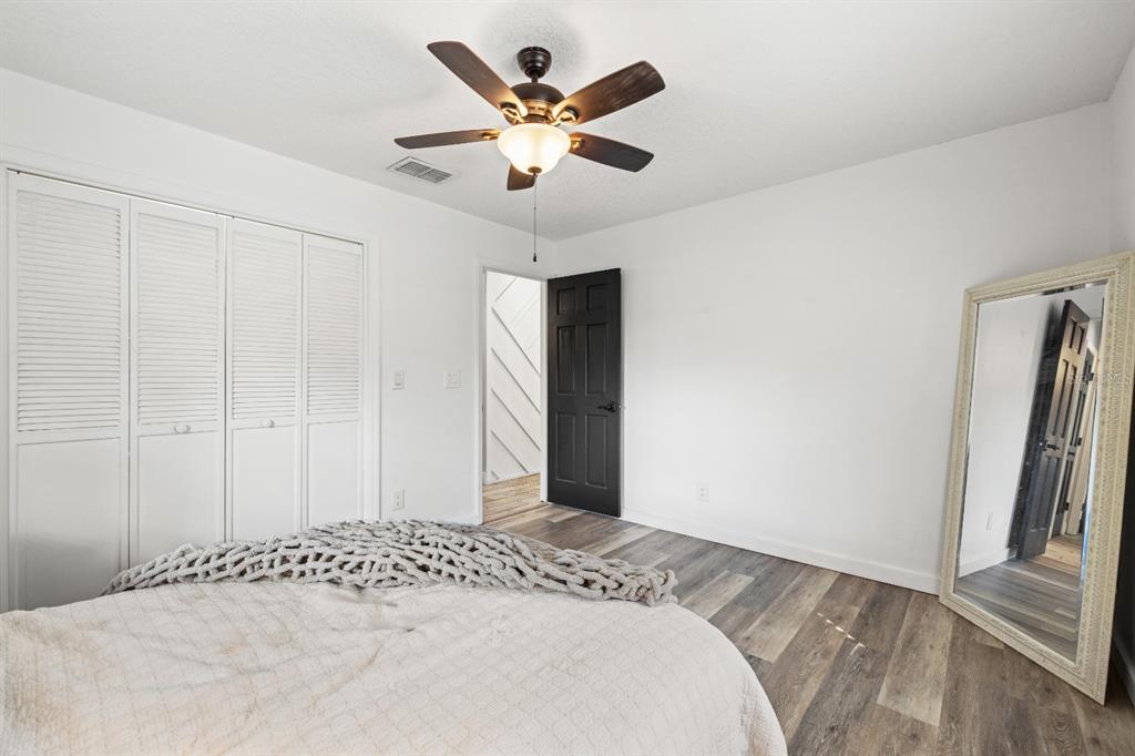 12414 Fort King Road Dade City, FL 33525 - Photo 37 of 60 a bedroom with a large bed and a ceiling fan