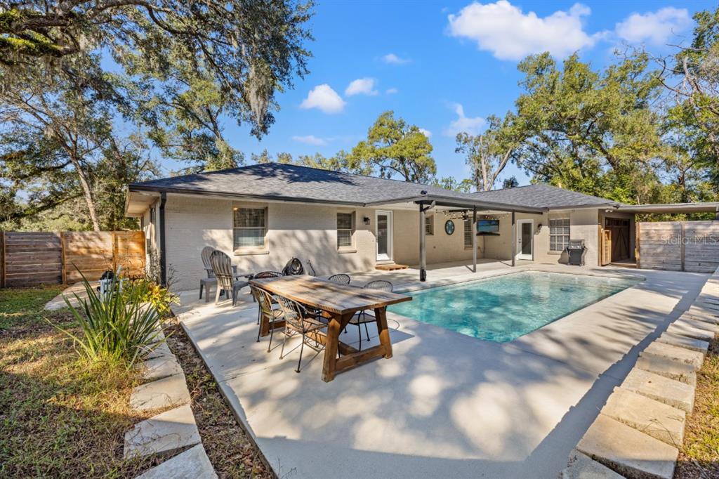 12414 Fort King Road Dade City, FL 33525 - Photo 49 of 60 a view of a patio with table and chairs with wooden floor and fence