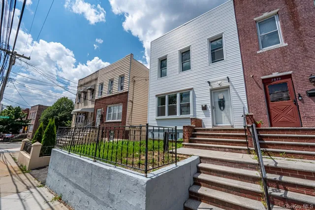 a view of a house with a small yard and wooden fence