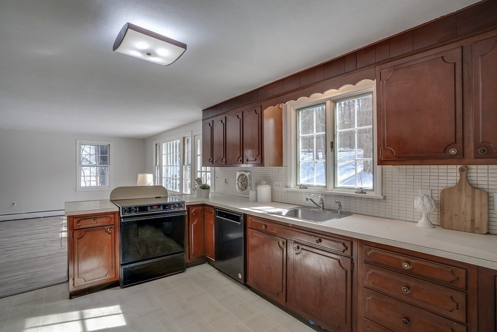76 Brook Trail Road Concord, MA 01742 - Photo 11 of 33 a kitchen with stainless steel appliances granite countertop a sink stove and cabinets